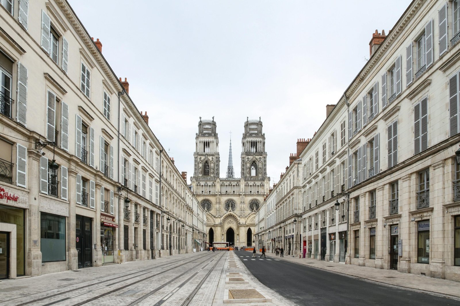 Capture of the magnificent Orléans Cathedral surrounded by classic French architecture on a quiet street.